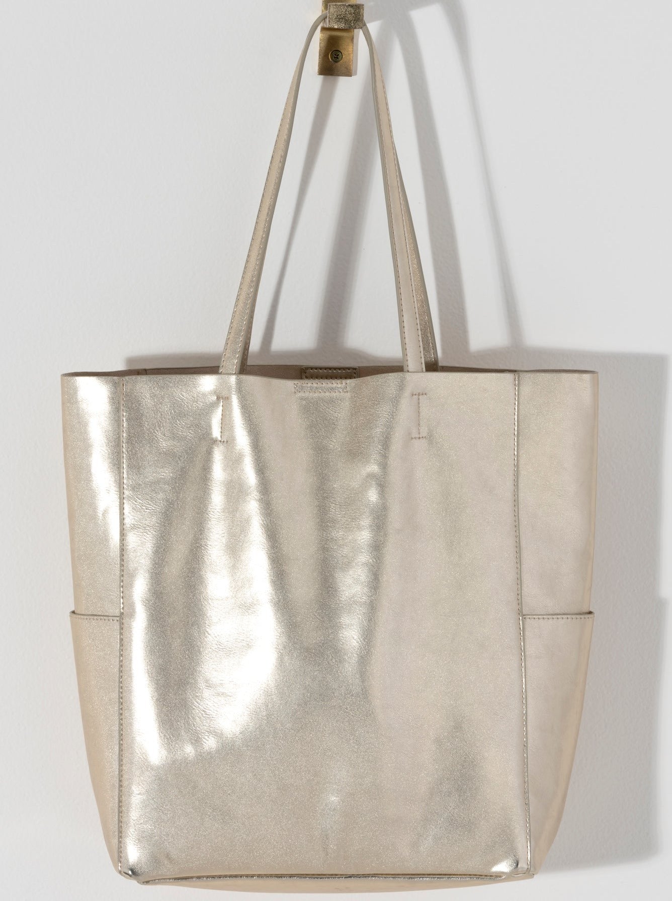 Make a statement this summer with Shiraleah's Maddie Tote. Made from metallic PU, this shiny accessory is sure to turn heads. With double shoulder straps and plenty of storage room, you won't need another bag to get you through this summer. Pair with other Shiraleah items to complete your look!
